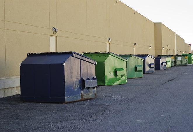 a compact construction dumpster being emptied by a waste disposal truck in Coral Springs